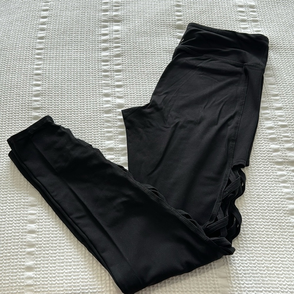 women’s black leggings with criss-cross cut outs along outer part (size: M)